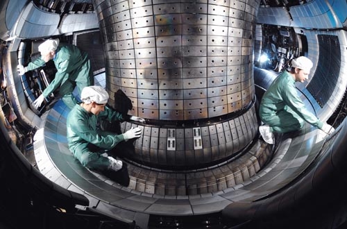 Des spécialistes installent des bobines de régulation dans la chambre à plasma de l'installation de fusion Asdex Upgrade.
