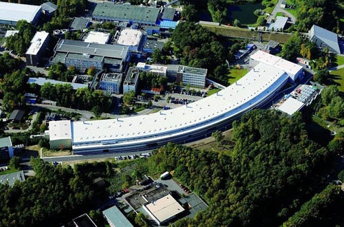 Blick auf das Desy-Gelände: Vorne erstreckt sich die knapp 300 m lange, geschwungene Experimentierhalle von Petra III. In ihr werden 27 Experimente aufgebaut.