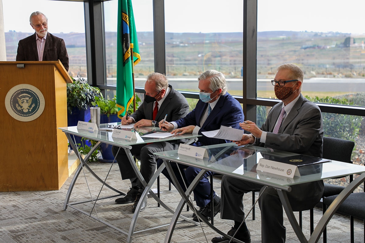Le député Dan Newhouse (tout à gauche) regarde Brad Sawatzke, CEO d’Energy Northwest, Clay Sell, CEO de X-Energy, et Kevin Nordt, CEO de Grant PUD signer la déclaration d’intention concernant le Tri Energy Partnership.